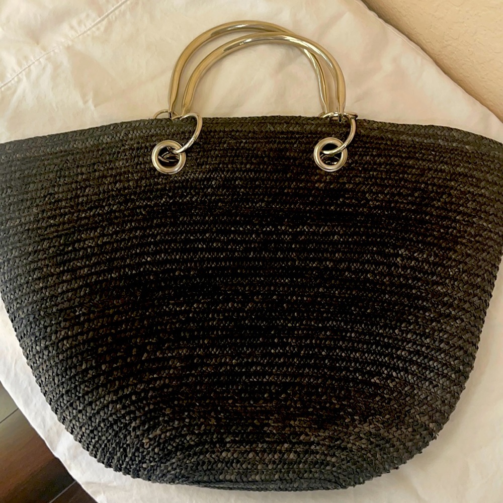 A woman’s black straw purse/handbag with chrome handles